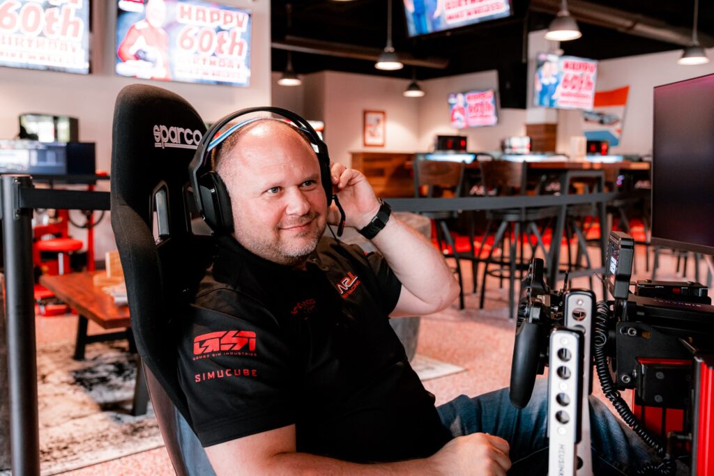 John sitting in a sim pod.